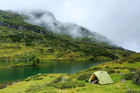 Hiker cooks in front of the tent