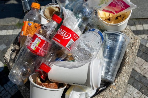 Full rubbish bin with lots of plastic waste and empty plastic bottles