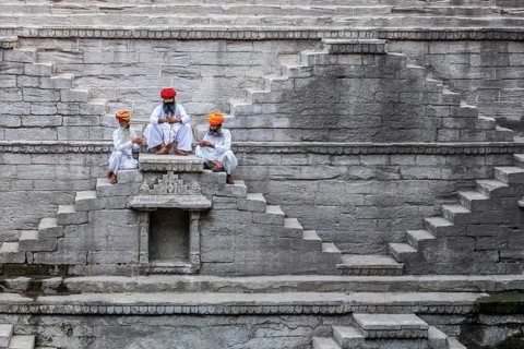 Three men playing cards at the stepwell Toorji Ka Jhalra