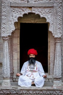 Man practicing yoga in a window at the stepwell Toorji Ka Jhalra Jodhpur