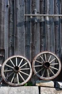 Two old wagon wheels in front of a barn