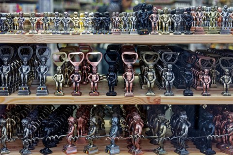Small Manneken Pis figures as bottle openers and corkscrews in display in shop window