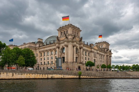Reichstag with waving German flag at the Spree