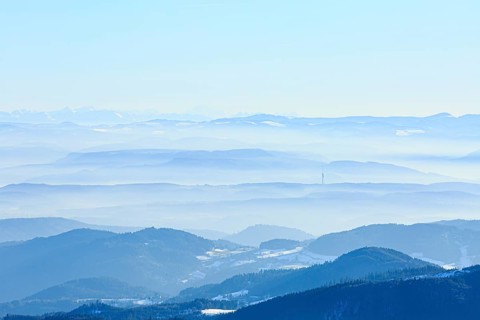 View from the summit of the Belchen to snow-covered mountain and alpine ranges