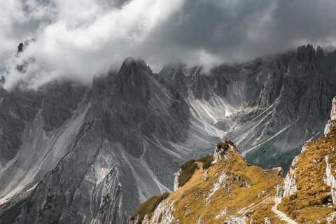 Woman in red jacket standing on a ridge