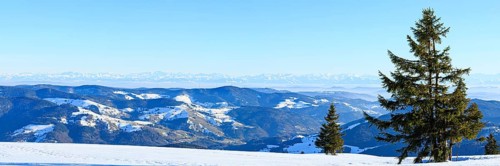 View from the snow-covered summit of the Belchen to mountain ranges and alpine chain Black Forest