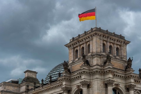 Reichstag with waving German flag at the Spree