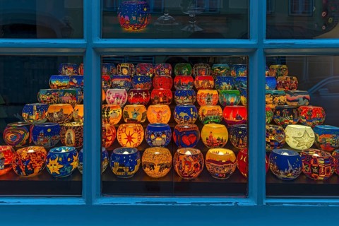 Colourful painted illuminated lanterns with Christmas motifs in a shop window