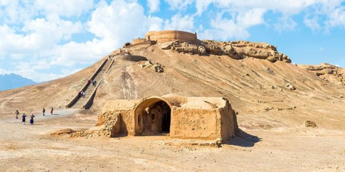 Ruins of ritual buildings in front of Dakhmeh Zoroastrian Tower of Silence