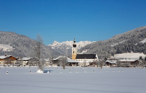 Village with parish church in winter