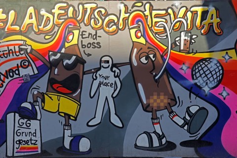 Colourful graffiti La Deutsche Vita at a construction site barrier