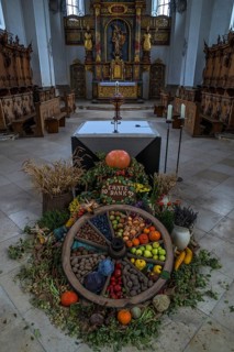 Wagon wheel decorated with vegetables for Thanksgiving in front of the high altar in the church