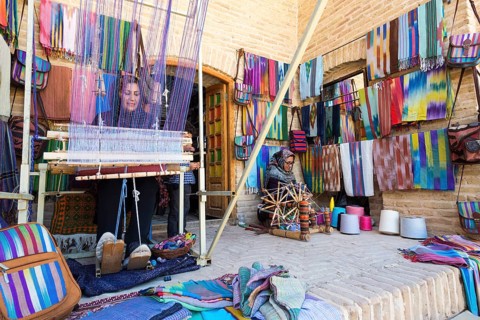 Iranian woman weaving a carpet