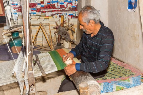 Iranian man working on a loom