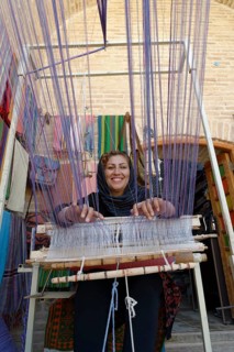 Iranian woman weaving a carpet