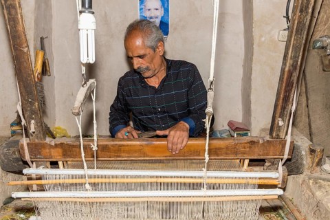 Iranian man working on a loom