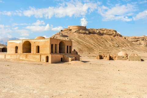 Ruins of ritual buildings in front of Dakhmeh Zoroastrian Tower of Silence