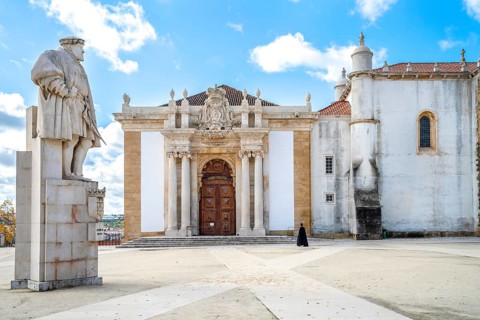 A student in traditional cloth walking through University of Coimbra