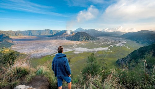 Young man in front of volcanic landscape