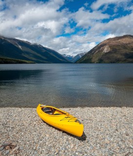 Yellow kayak on pebble beach
