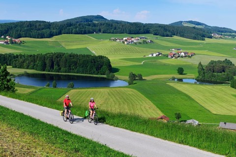 Couple with electric bikes at Buchberg with view of Lake Grossegelsee