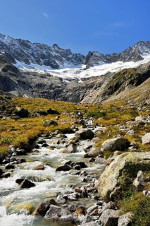 Damma glacier in front of a torrent in autumnal surroundings