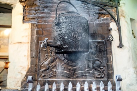 Vintage kettle on fireplace in old English pub