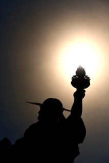 Statue of Liberty holds her torch into the sun