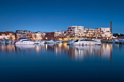 City harbour with modern hotel complex at dusk