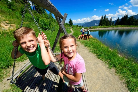 Family playing during a hike at the storage lake at the middle station