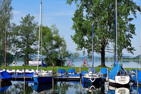 Couple with electric bikes in the port of Matzing on Lake Wallersee