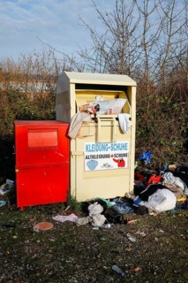 Overfilled old clothes container for clothes and shoes