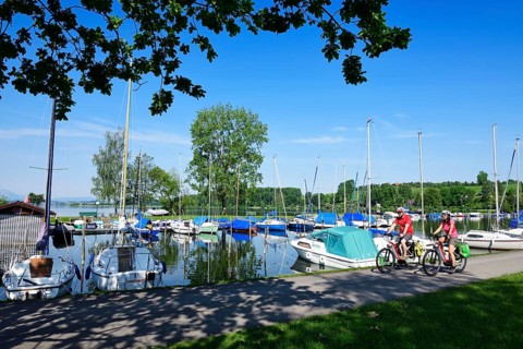 Couple with electric bikes in the port of Matzing on Lake Wallersee