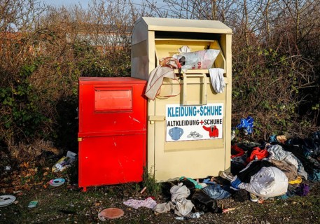 Overfilled old clothes container for clothes and shoes