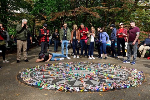 Tourists photograph the John Lennon Memorial