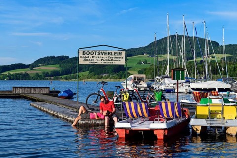 Couple with electric bikes pauses on a landing stage at Lake Obertrumer See