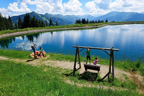 Family playing during a hike at the storage lake at the middle station