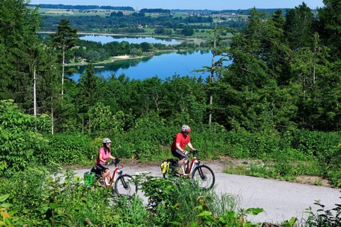Couple with electric bikes riding above Lake Mattsee