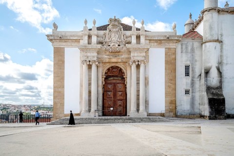 A student in traditional cloth walking through University of Coimbra