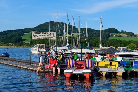 Couple with electric bikes pauses on a landing stage at Lake Obertrumer See