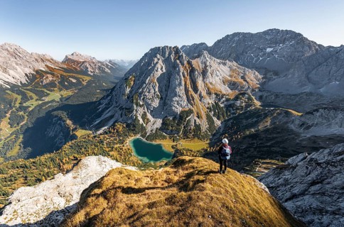 Young woman with climbing helmet looking at Seebensee from the Ehrwalder Sonnenspitze