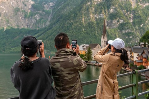 Asian tourists photograph the old town of Hallstatt