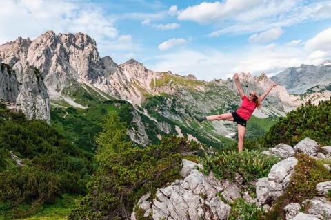 Young woman stretches arms in the air
