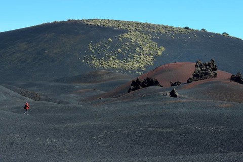 Wandering woman in volcanic lunar landscape