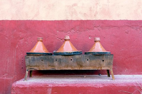 Three clay tagine pots on portable barbeque