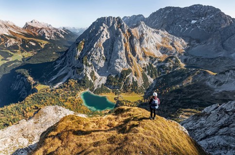 Young woman with climbing helmet looking at Seebensee from the Ehrwalder Sonnenspitze