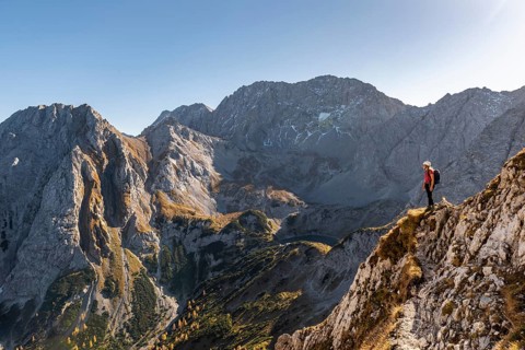 Mountaineer with climbing helmet stands on a rocky outcrop