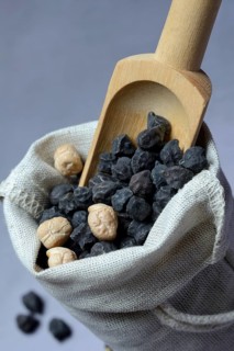 Black and white chick peas in sacks with wooden shovel
