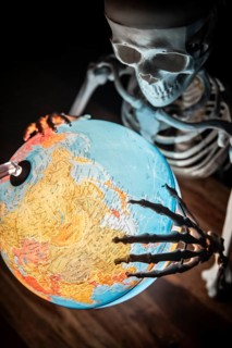 Skeleton with bony hand on globe