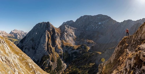 Mountaineer with climbing helmet stands on a rocky outcrop